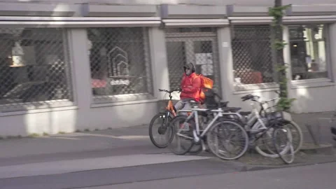 Delivery Guy Thuisbezorgd biking through Amsterdam Stock Footage 130209459