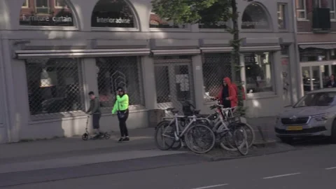 Delivery Guy Thuisbezorgd biking through Amsterdam Stock Footage 130209505