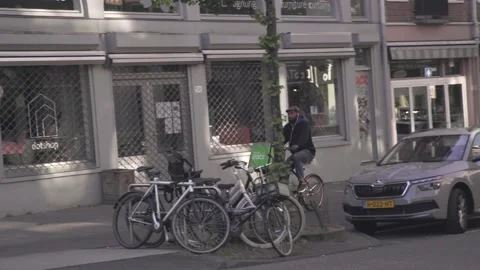 Delivery Guy Thuisbezorgd biking through Amsterdam Stock Footage 130237074