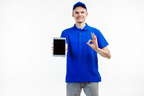 Delivery guy turns tablet screen towards the camera. Stock Photos