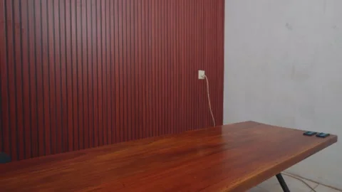 Delivery of a large black plastic-wrapped package on a wooden table. Stock Footage 333322037