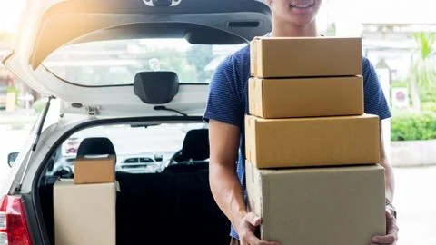 Delivery Loader Postman in blue uniform holding pile of cardboard box or carr Foto stock