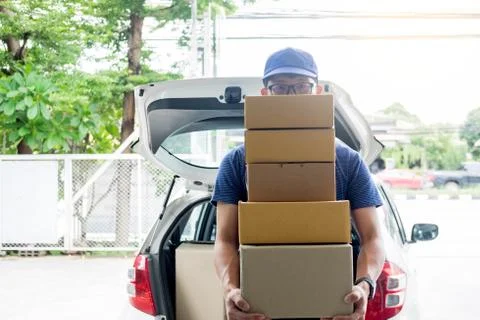 Delivery Loader Postman in blue uniform holding pile of cardboard box or carr Foto stock