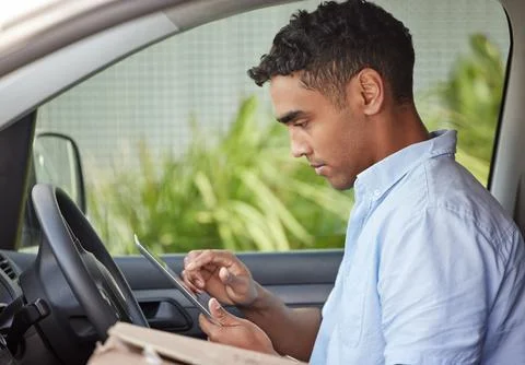 Delivery man in car with tablet, boxes and checking location, order list or Stock-Fotos