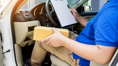 Delivery man with cardboard box checking document list In van and parcels o.. Stock Photos