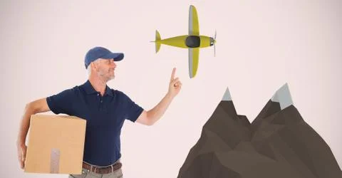 Delivery man carrying parcel while pointing at airplane 스톡 사진