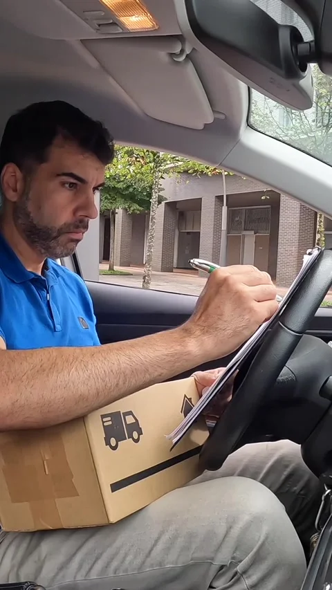 Delivery man checking delivery packages inside a car Stock Footage 286408013