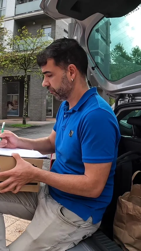 Delivery man checking delivery packages inside a car Stock Footage 286408072