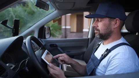 Delivery man checking orders on tablet in car Video stock 114924456