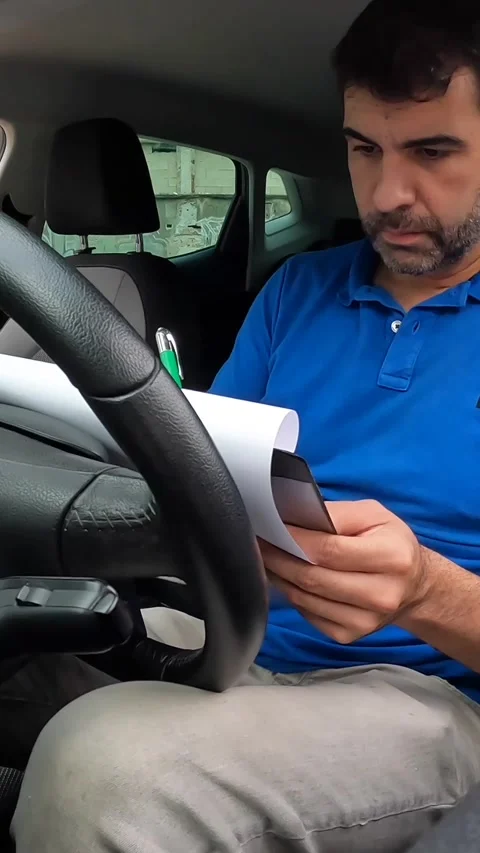 Delivery man checking a package sitting inside a car Stock Footage 286408147