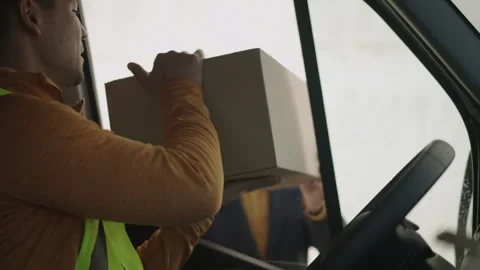 Delivery man collecting a return parcel, a man handing him the package Stock Footage 263896060