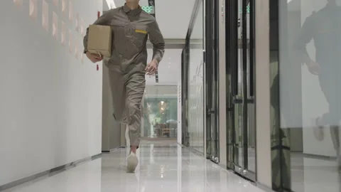 Delivery man courier in uniform running, holding cardboard package box deliver Stock Footage 331316664
