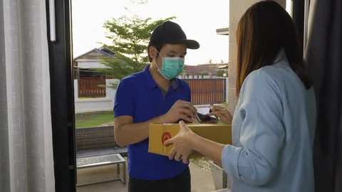 Delivery man delivering a parcel box to customer woman at home Stockbeeldmateriaal 128940961