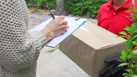 Delivery man delivering parcels to the customer at home. Vídeos de archivo 138287465