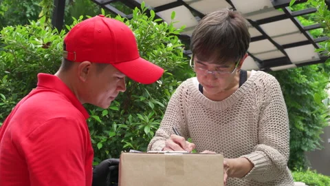 Delivery man delivering parcels to the customer at home. Stock Footage 138287491