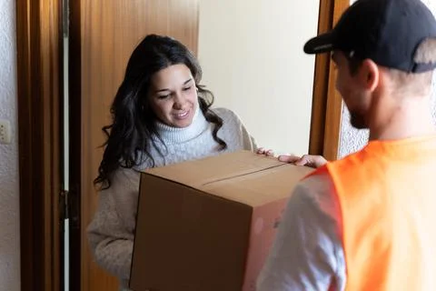 Delivery Man dispatching a cardboard box to a happy customer Stock Photos