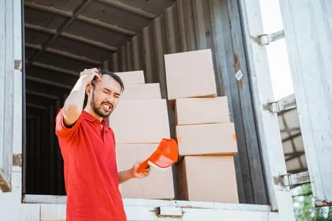 Delivery man dizzy while working with cardboard boxes Stock Photos