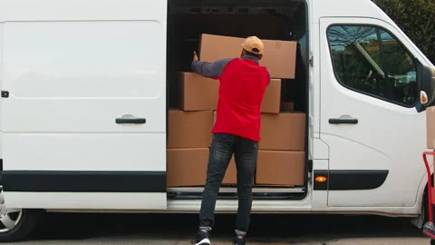 Delivery man with face mask putting parcel into the van. Delivery during covid Stock Footage 150645241