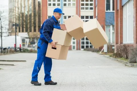 Delivery Man With Falling Stack Of Boxes On Street Stock Photos