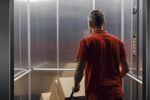 Delivery man getting in the elevator Stock Photos