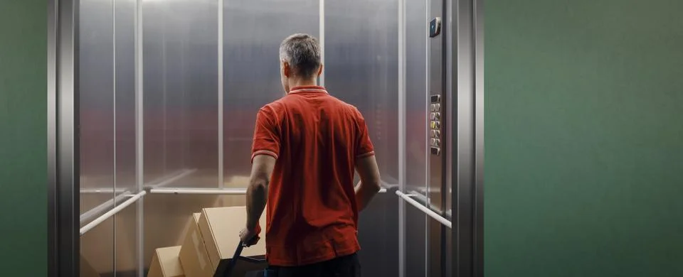 Delivery man getting in the elevator Stock Photos
