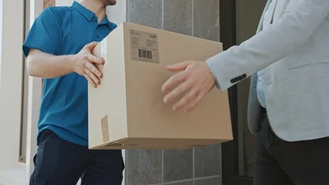 Delivery Man Gives Postal Package to Customer, Who Signs Electronic Signature Stock Footage 116090247