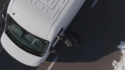 Delivery man giving a parcel to a costumer of the drivers seat window  Video stock 263896624