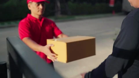 A delivery man grabs a parcel box and gives it to the customer Stock Footage 245362320