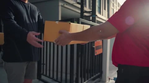 A delivery man grabs a parcel box and gives it to the customer Stock Footage 245362324