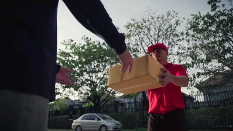 A delivery man grabs a parcel box and gives it to the customer Stock Footage 245362338