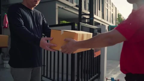 A delivery man grabs a parcel box and gives it to the customer Stock Footage 245362348