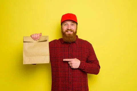 Delivery man with hat and beard has an happy expression Foto stock