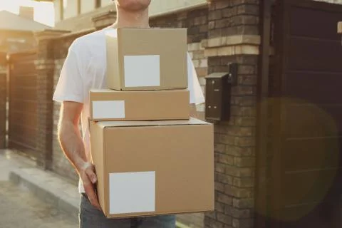 Delivery man hold blank boxes outdoor, space for text Foto stock