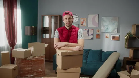 Delivery man holding boxes in new apartment and crossing hands. Mover carrying Stock Footage 150442892
