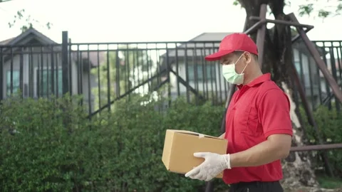 Delivery man holding parcel boxes finding Customer home Village Stock Footage 243070641