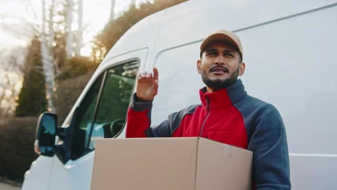 Delivery man holding parcel in front of transportation van Stock Footage 150659329