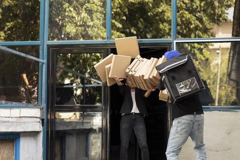 Delivery man lets a tall stack of pizza boxes crash to the floor 写真素材