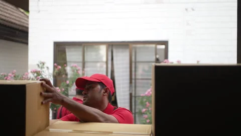Delivery man move items to the house. Stock Footage 245284202