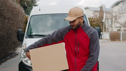 Delivery man with package pointing finger towards camera and giving parcel Stock Footage 150660479