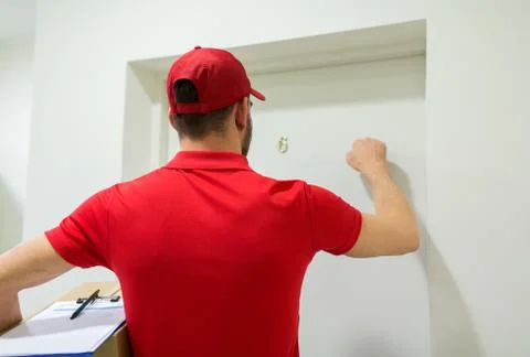 Delivery man with parcel box knocking door Stockfoto's