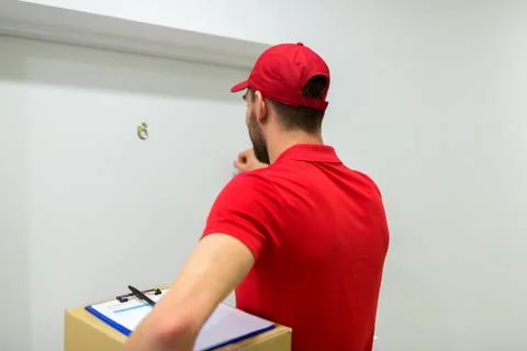 Delivery man with parcel box knocking door Stockfoto's
