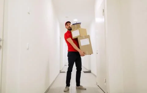 Delivery man with parcel boxes in corridor Foto stock