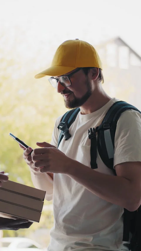 Delivery man with pizza boxes using a smartphone Stock Footage 320323992