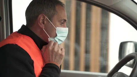 Delivery man putting on his face mask. 库存影片 149479688