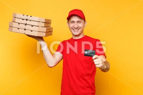 Delivery man in red cap t-shirt giving food order pizza boxes isolated on yellow Stock Photos