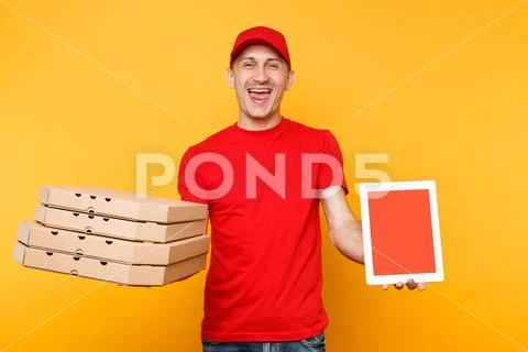 Delivery man in red cap t-shirt giving food order pizza in flatbox boxes on Stock Photos