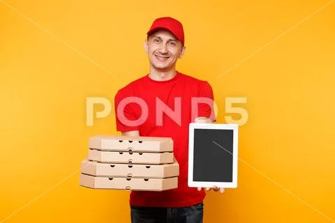 Delivery man in red cap t-shirt giving food order pizza in flatbox boxes on Stock Photos