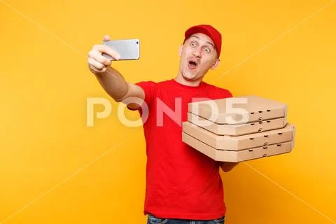 Delivery man in red cap t-shirt giving food order italian pizza in empty flatbox Stock Photos