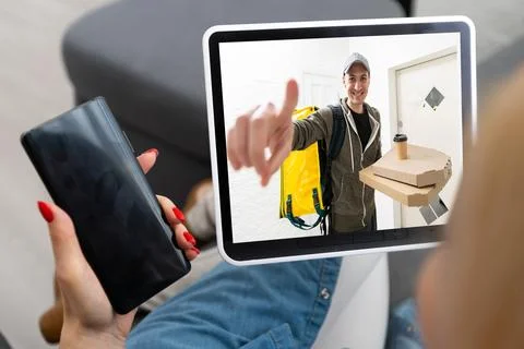 Delivery man ringing door bell on cctv secure camera system on tablet app Stock Photos