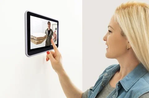 Delivery man ringing door bell on cctv secure camera system on tablet app Stock Photos